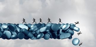 How Anesthesiologists Are Fighting the Opioid Crisis Opioid health risk and medical crisis with a prescription painkiller addiction epidemic represented by a group of people running away from a dangerous falling bridge of pills as a medicine addict problem.