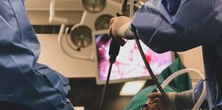 Laparoscopic Surgery vs. Open Surgery in Patients with Colorectal Cancer with Liver Metastases: No Change in Survival Surgeons using surgical instruments for keyhole surgery, watching the monitor which displays images from inside the patient's abdomen - operating theater with lights in the background.