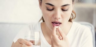 Some, but not all, Breast Cancer Patients Could Benefit from Aspirin Young woman taking aspirin
